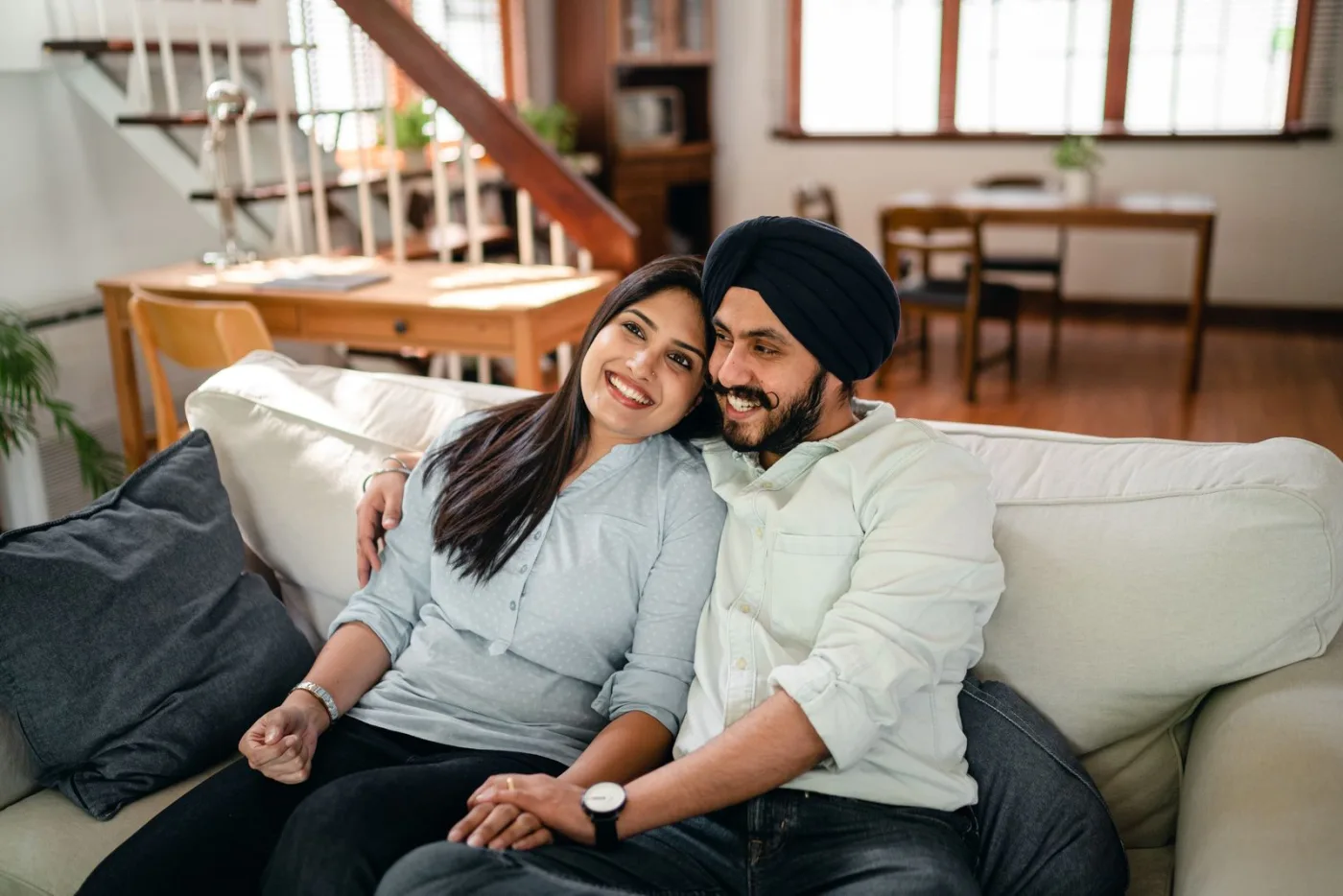 Indian couple relaxing together at home in their living room